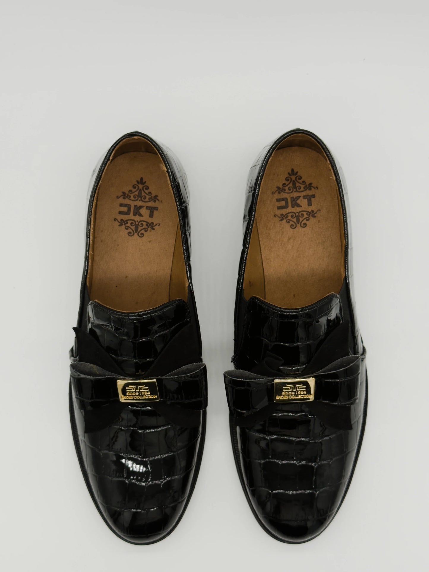 Mocasines negros clásicos para mujer con lazo y detalle dorado