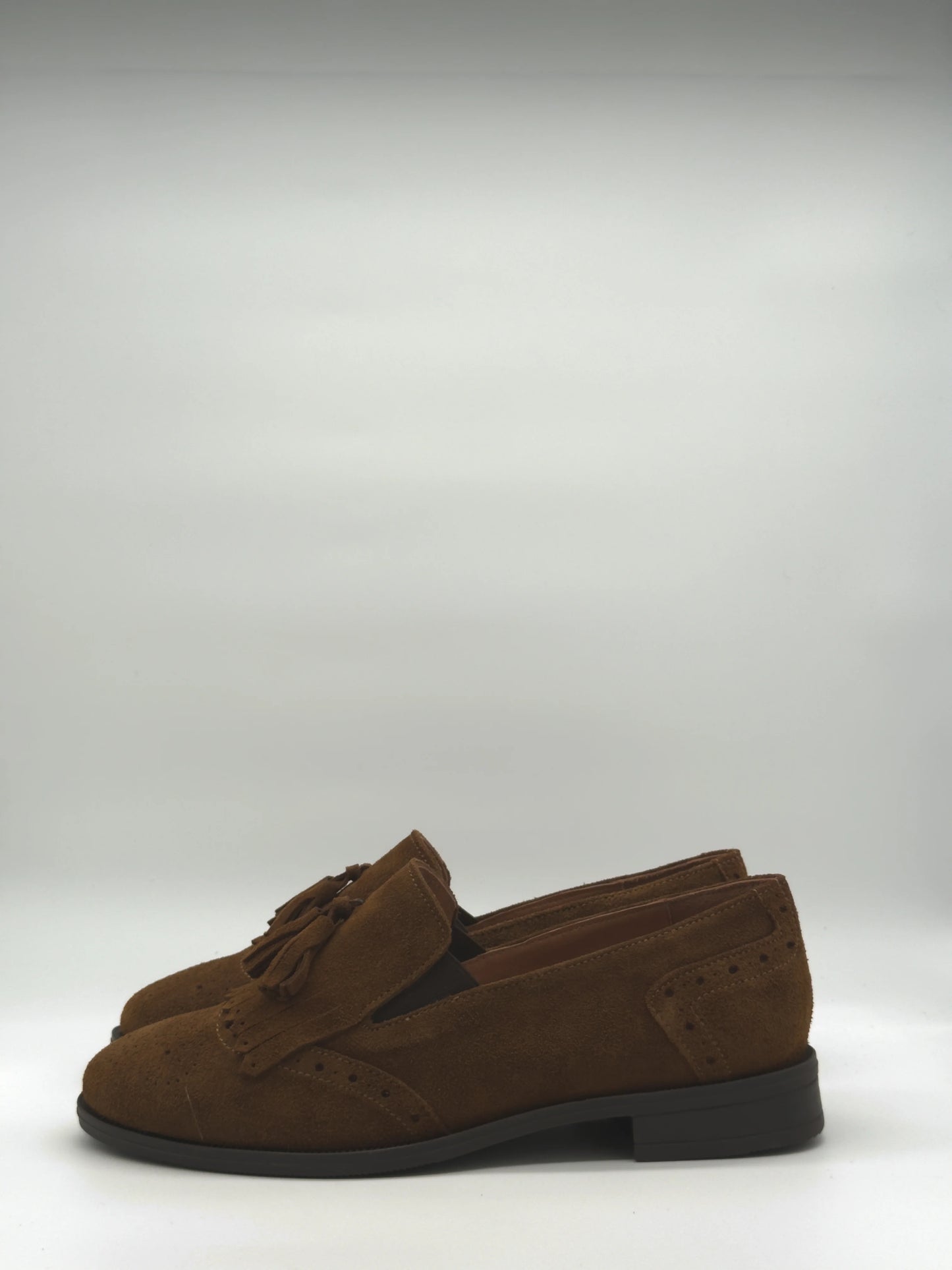 Mocasines clásicos con flecos y borla en color camel y taupe.