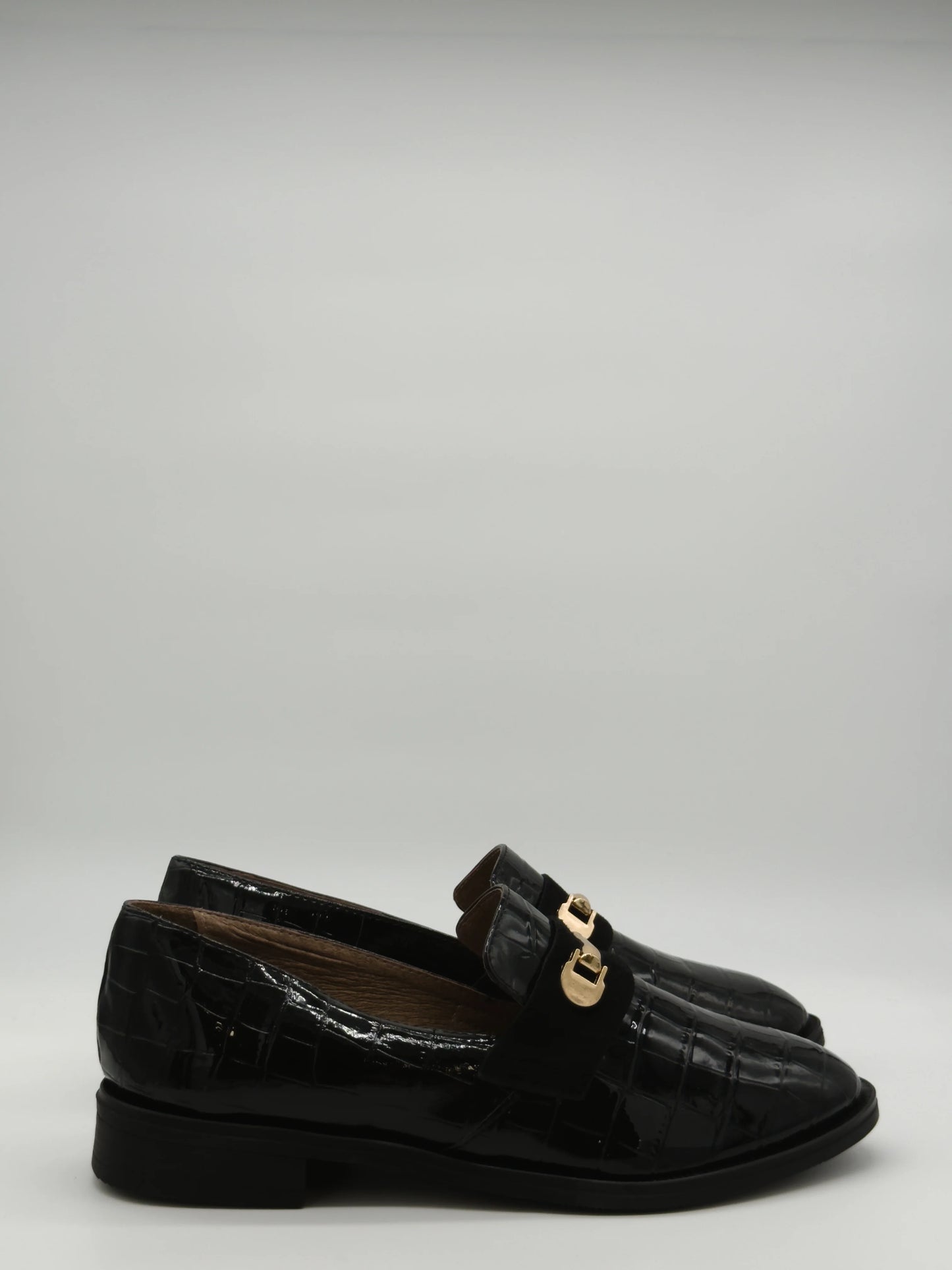 Mocasines negros clásicos para mujer con textura y detalle dorado