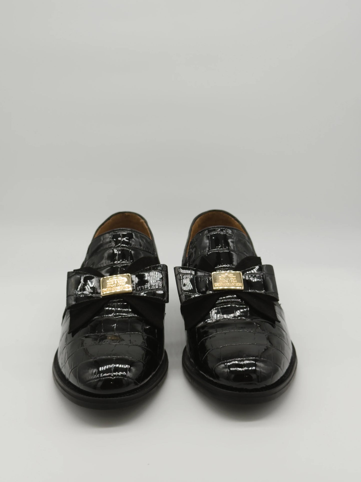 Mocasines negros clásicos para mujer con lazo y detalle dorado